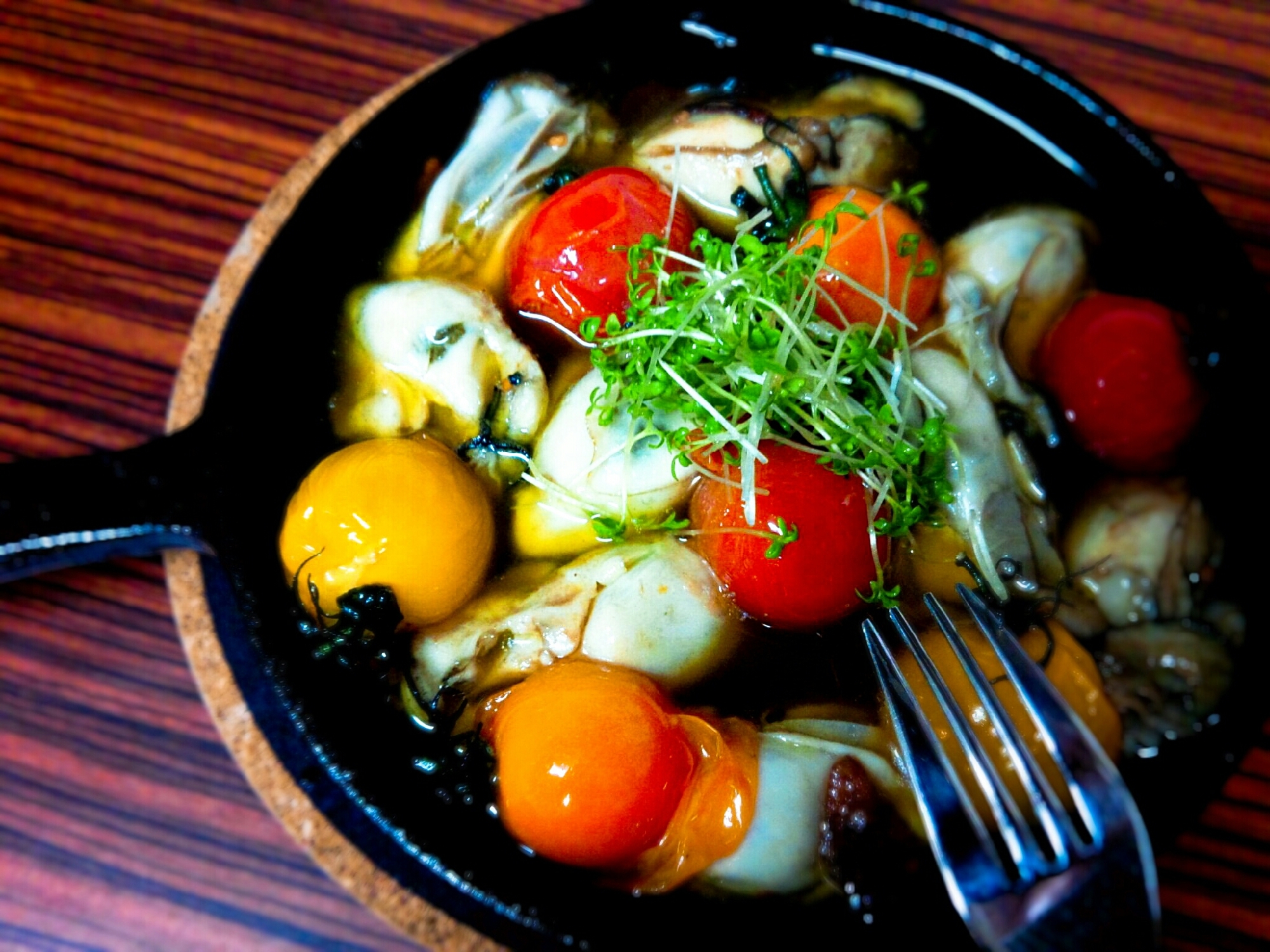 スキレットに牡蠣とミニトマトのアヒージョが盛られている様子