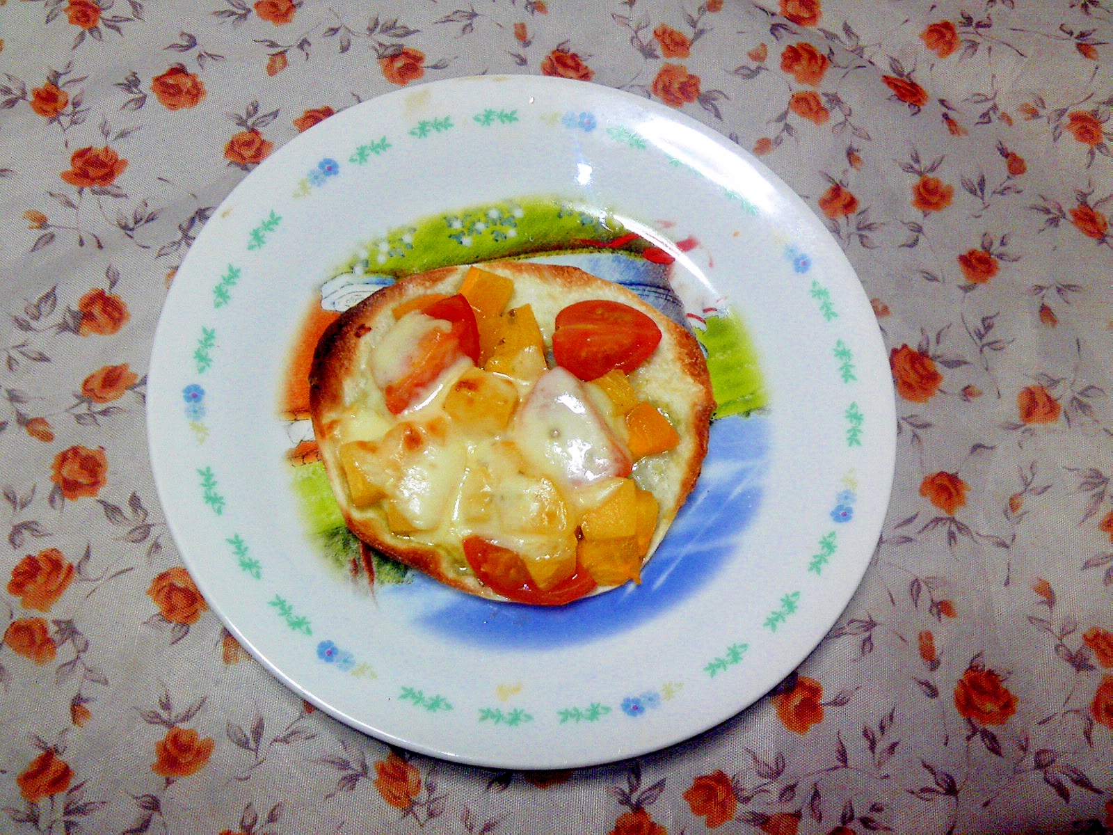 白い皿に盛られた柿とトマトのバジルソースピザ