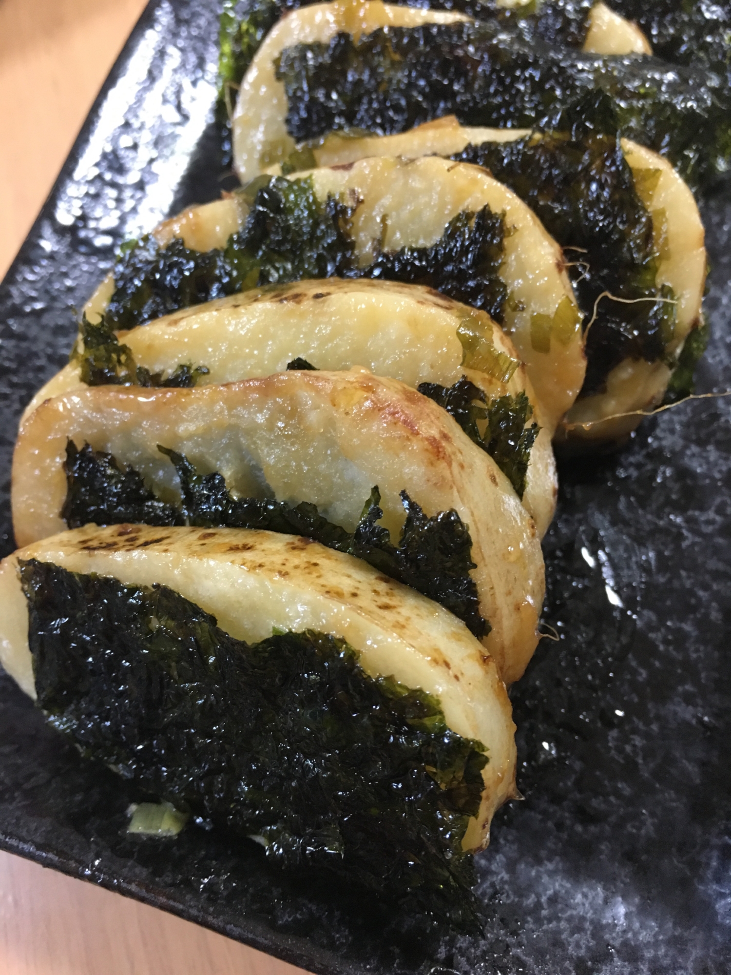 黒いお皿に山芋ステーキの韓国海苔包みが並べられている様子