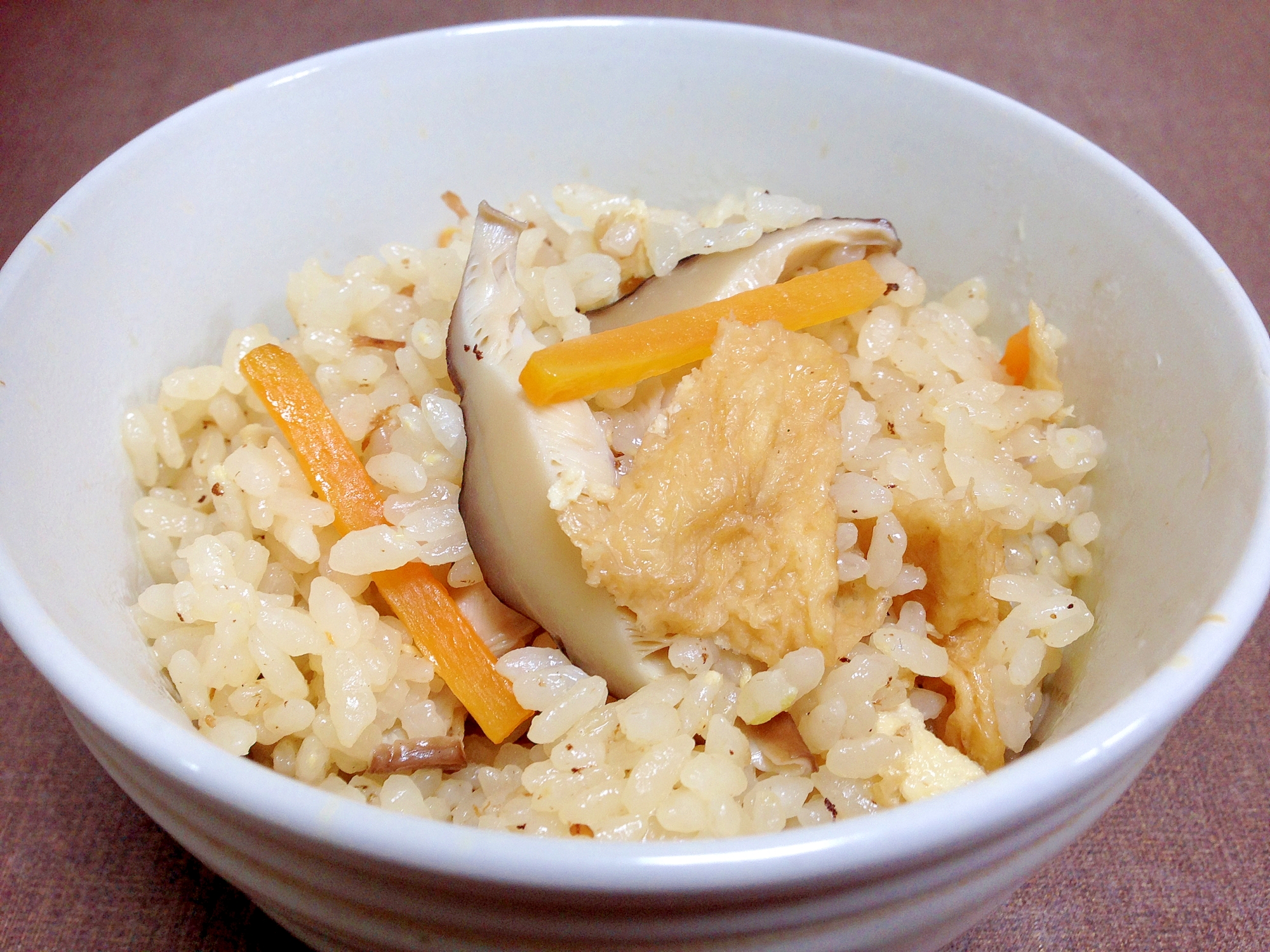 白い器に入ったにんじんやしいたけの炊込みごはん