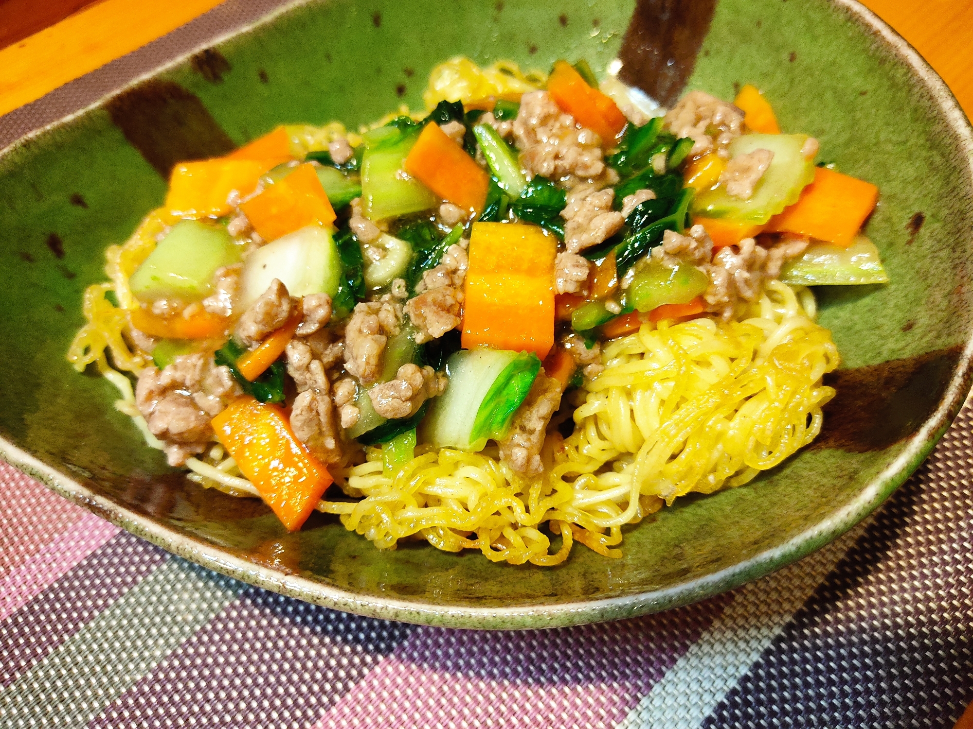 緑の皿に盛られている白菜とひき肉のあんかけかた焼きそば