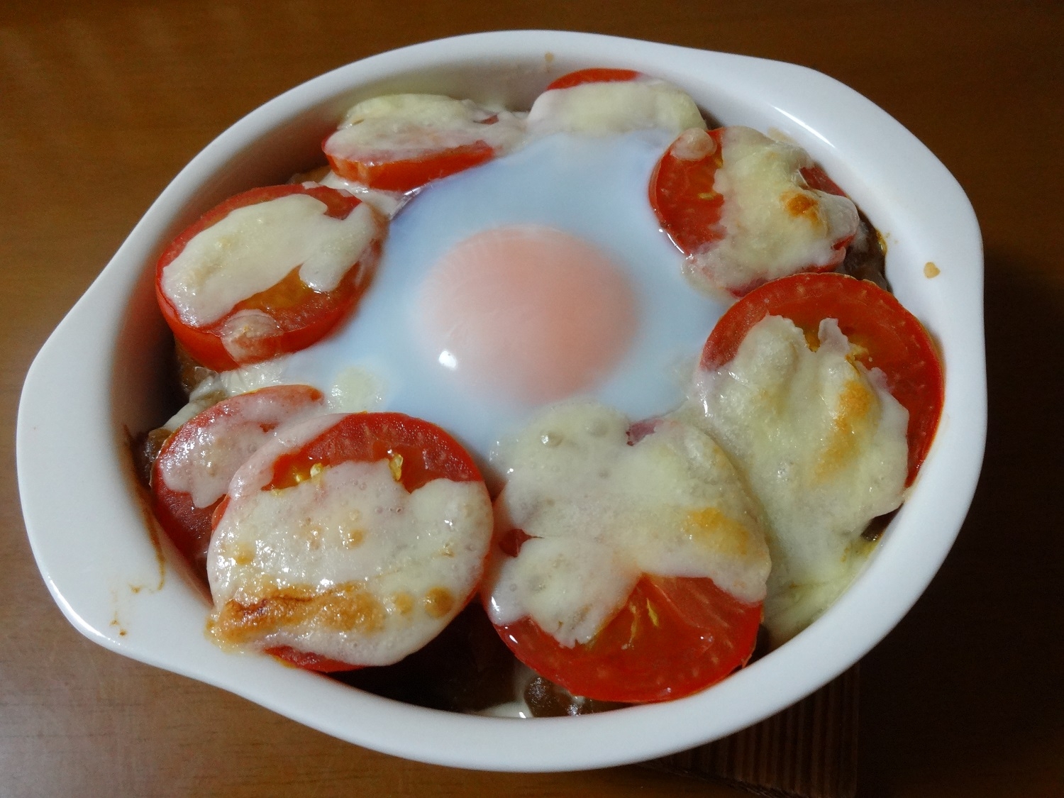 白い耐熱皿に盛られたトマト入りカレードリア