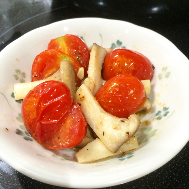 白の皿に盛られたミニトマト とエリンギの炒め物