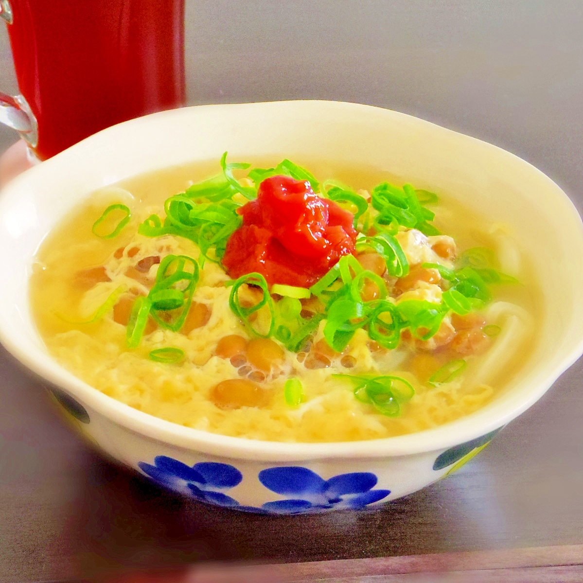 花柄の丼に盛られている梅と納豆と卵の温うどん