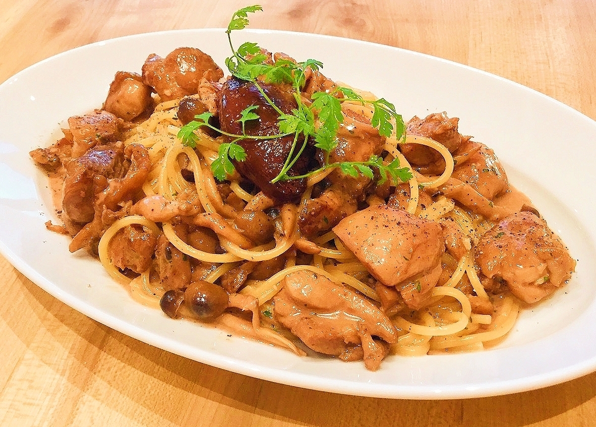 白い皿にのった鶏もも肉ときのこのチョコレートパスタ