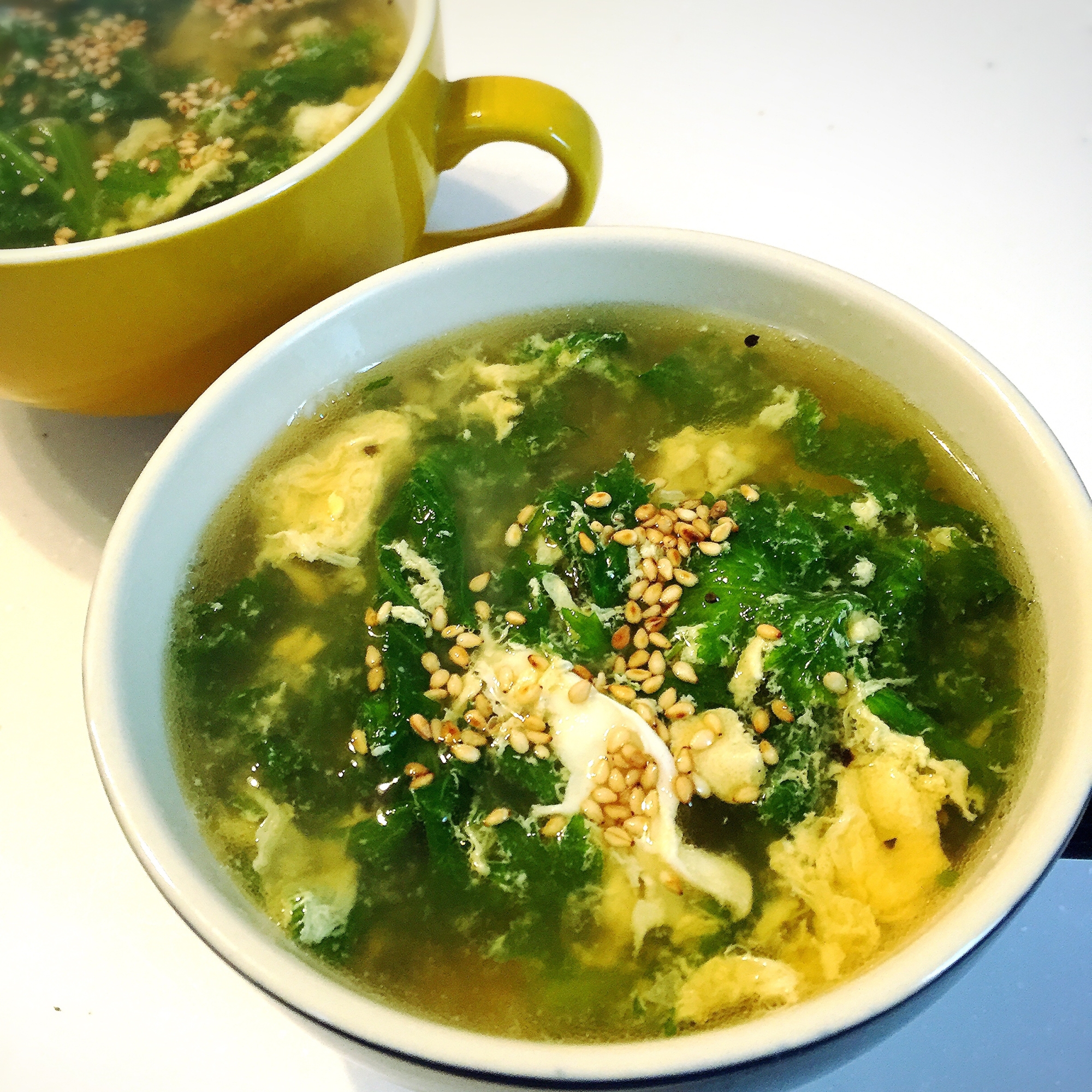 カップに盛られたわさび菜と卵の中華スープ