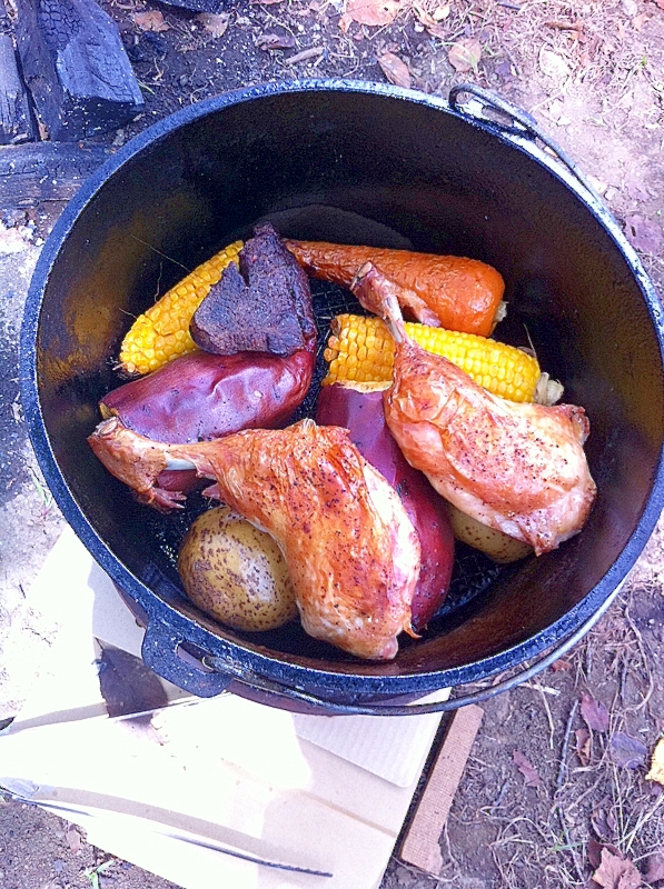 ダッチオーブンに入っている、骨付き鶏もも肉と野菜のハーブ焼き