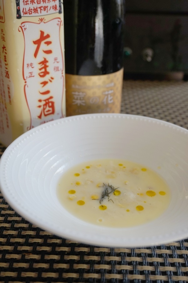 たまご酒のボトルと菜の花オイルの前にある卵酒のスープ