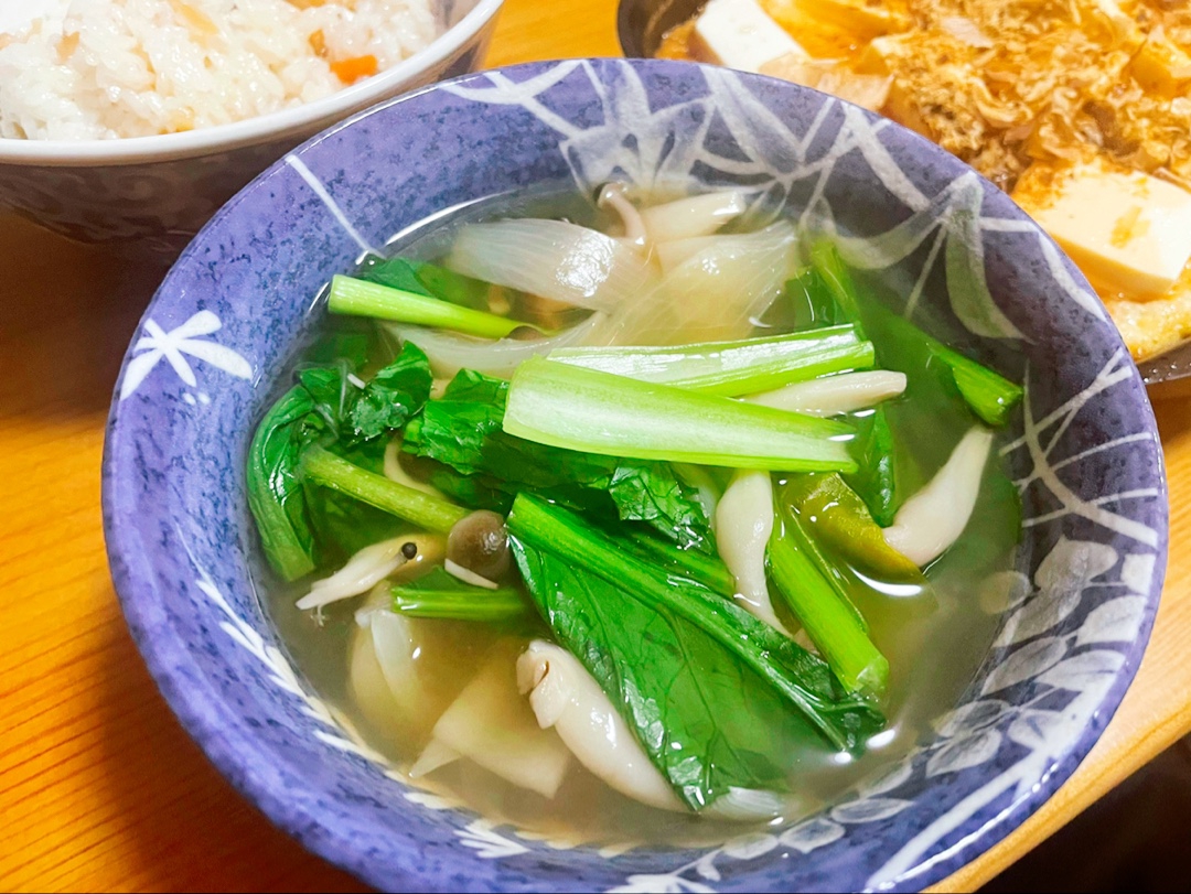 小松菜としめじが入ったそば湯の野菜汁が青いお椀に盛られている様子