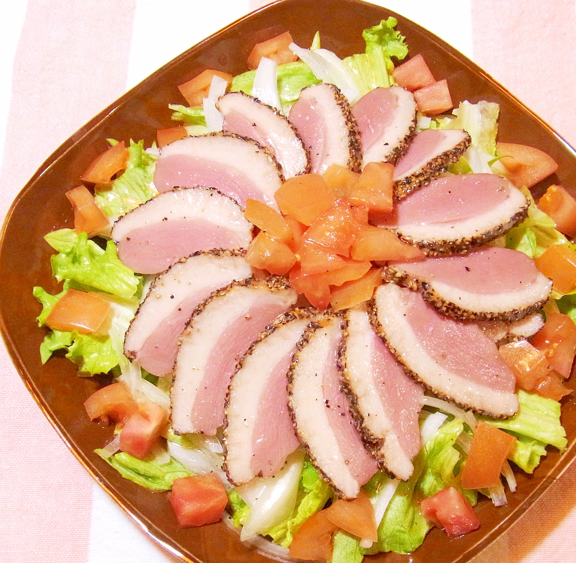 茶色い皿に盛られた鴨肉のサラダ