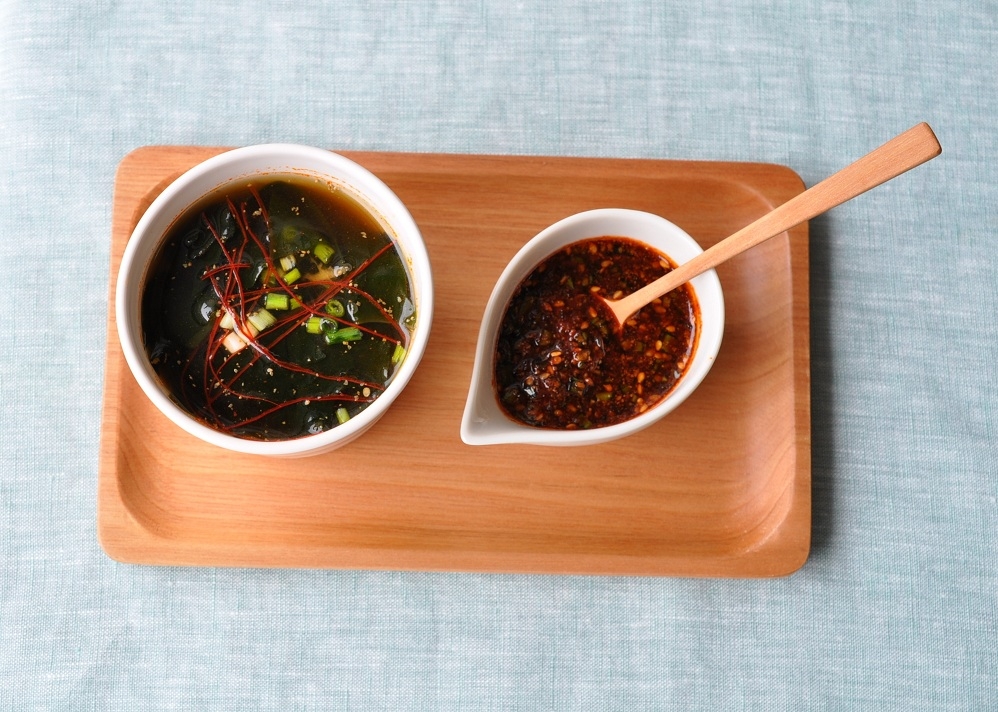 木製のプレートにのった韓国風ピリ辛わかめスープとヤンニョンジャン