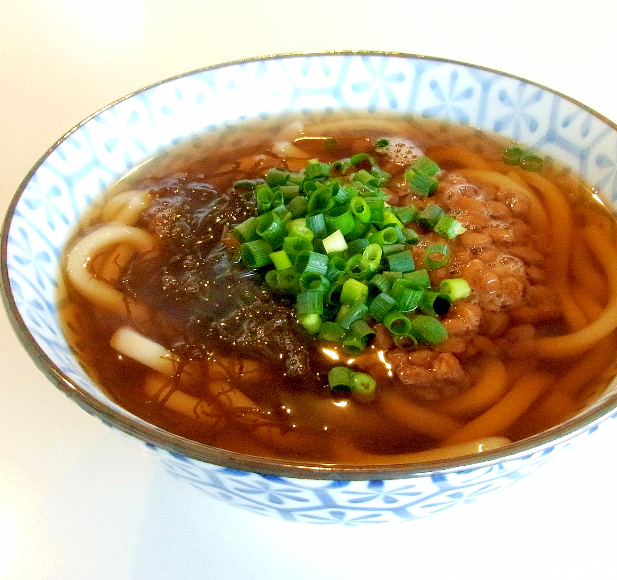 彩りに万能ねぎをのせた納豆ともずくのうどん