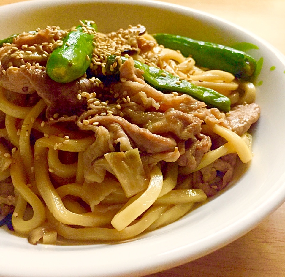 白い皿に盛られた、豚肉とししとうがらしの焼きうどん