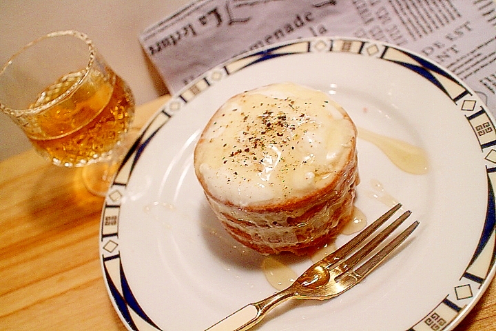 白い丸皿に盛り付けたスティルトン・ブルーチーズケーキと金のフォーク