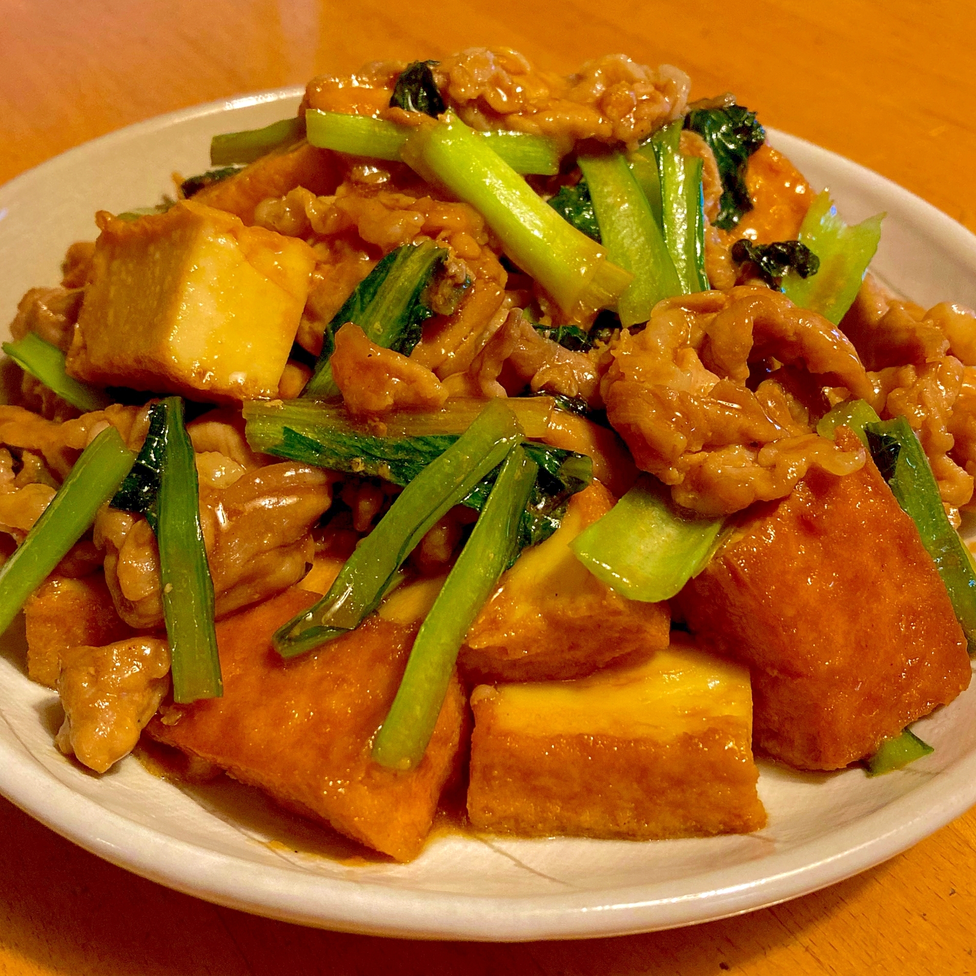 白い皿に盛り付けられている厚揚げと小松菜の中華風炒め