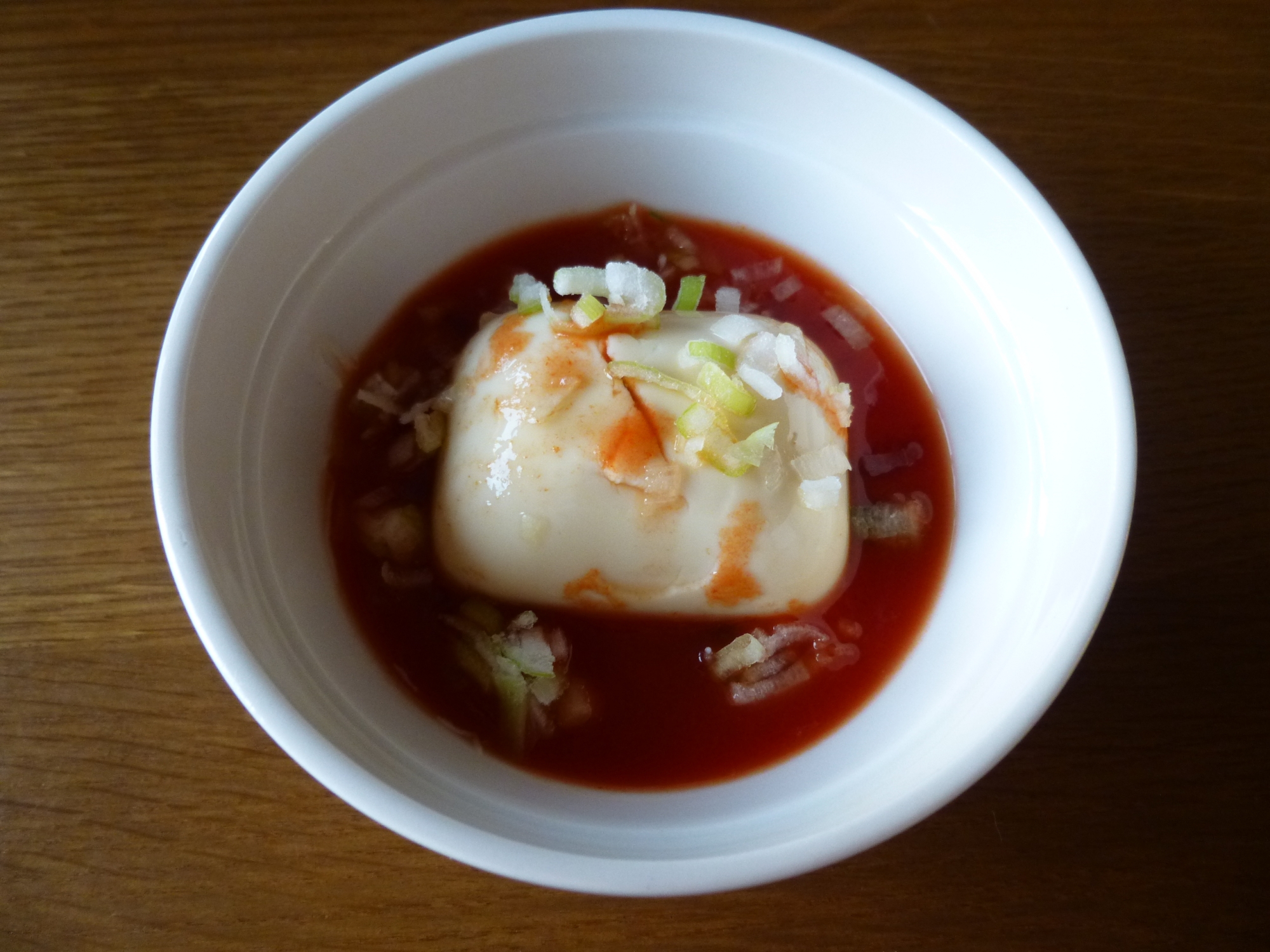 白い深鉢に盛りつけられたトマトジュースつゆの湯豆腐