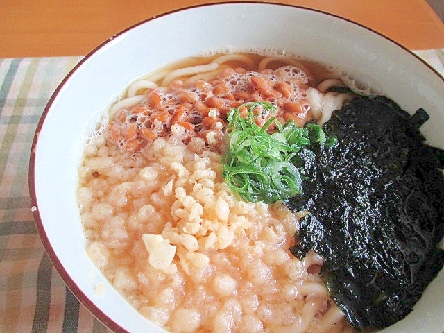 白い器に盛られている海苔と天かすの納豆うどん