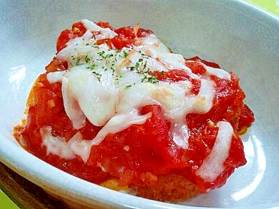 白い耐熱皿に入っているコロッケのトマトチーズ焼き