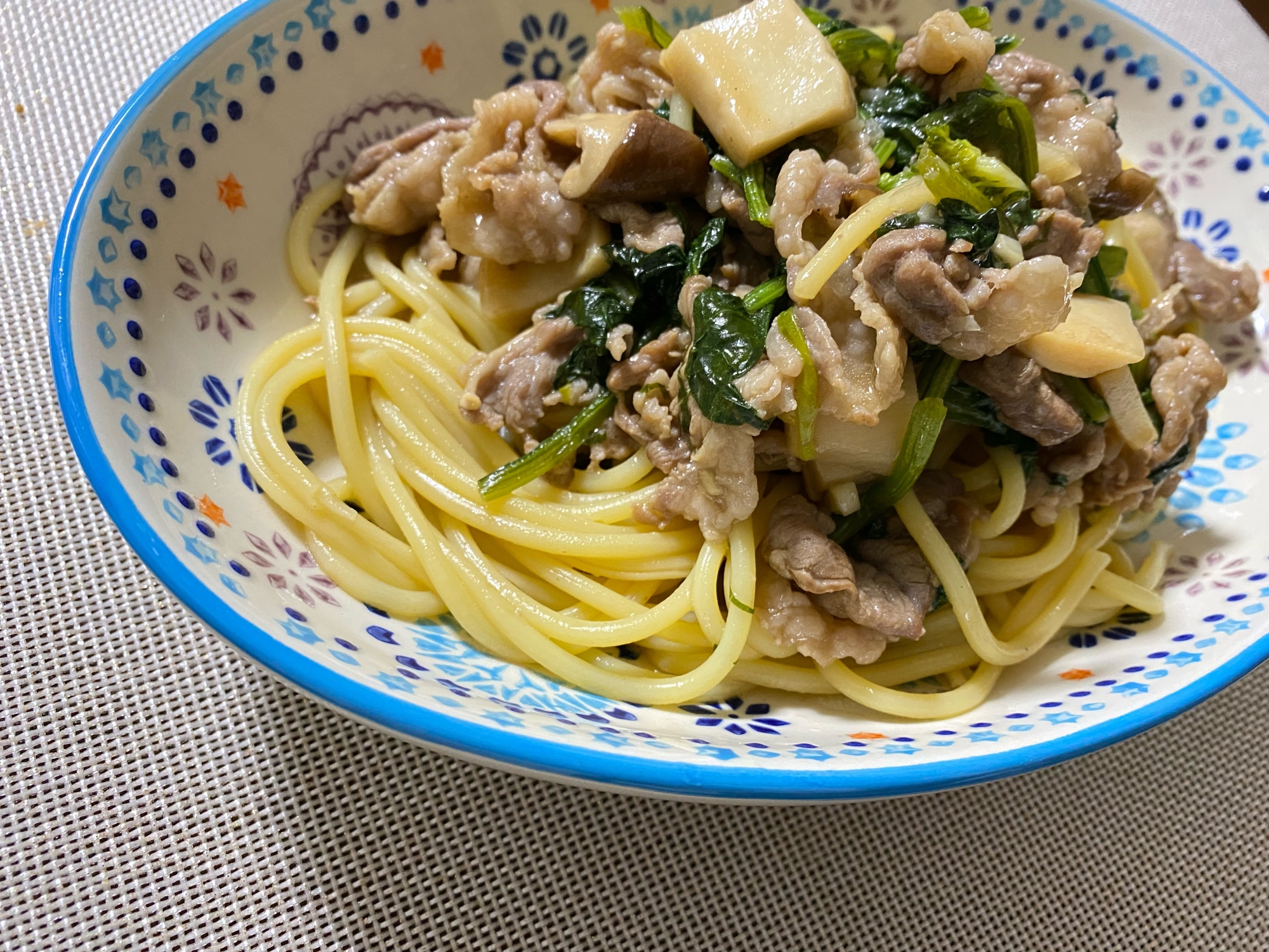 花柄の皿に盛り付けられている牛肉とほうれん草のレモン風味パスタ