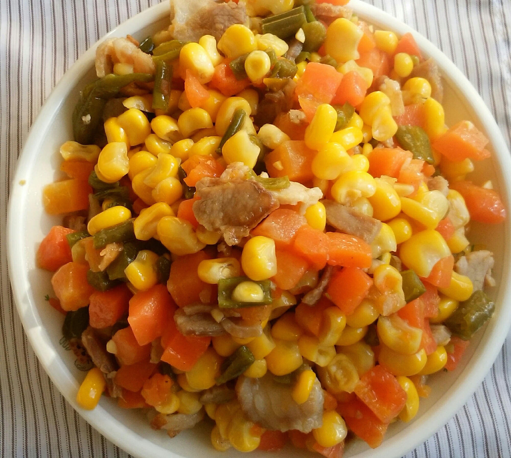 白い皿に盛り付けたミックスベジタブルとベーコンのバター炒め