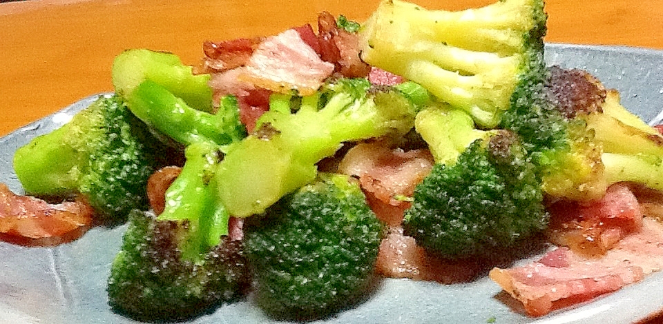 グレーの皿に盛り付けた冷凍ブロッコリーとベーコンの炒め物