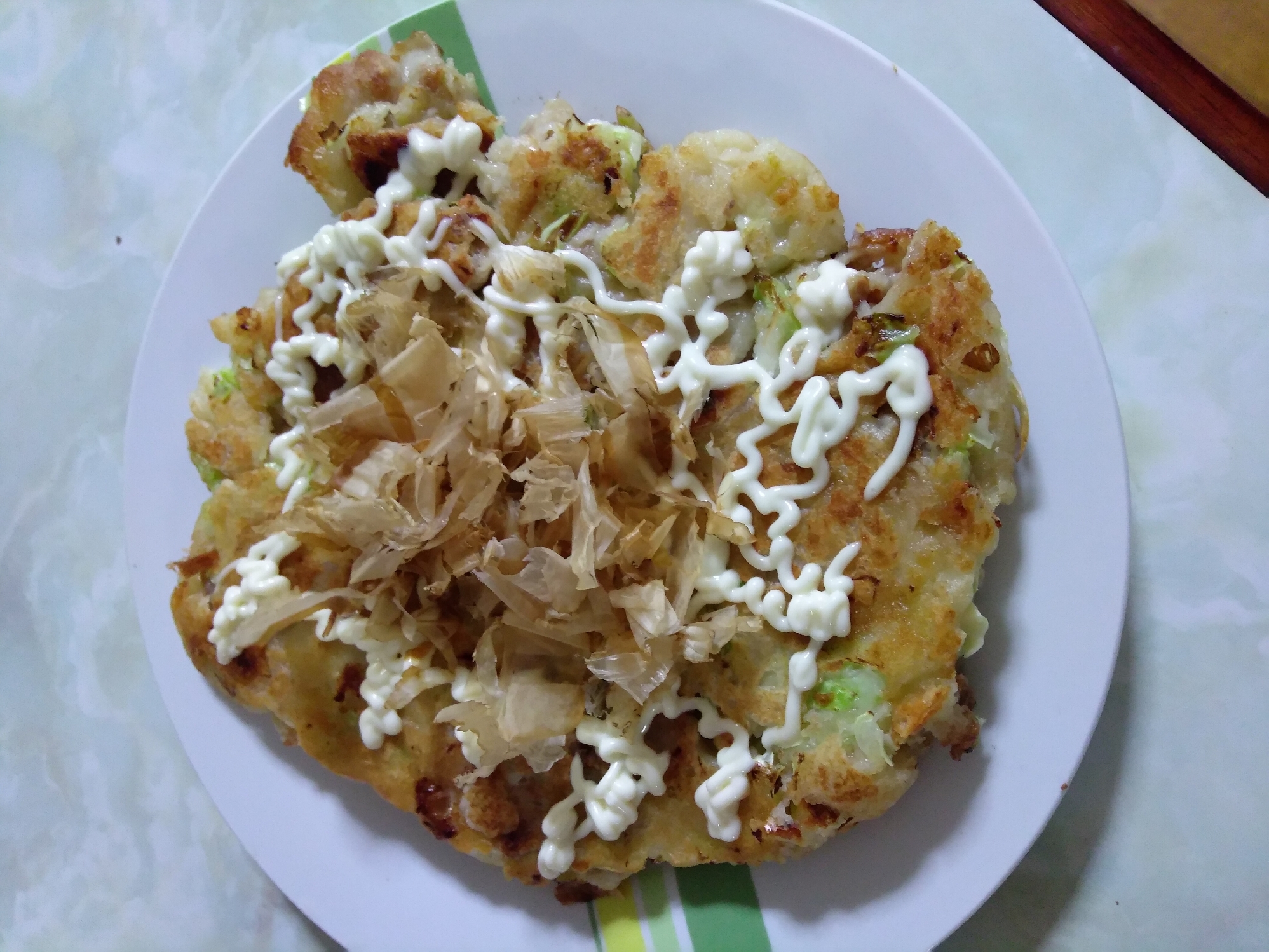 白い皿に盛られた生姜焼きのお好み焼き