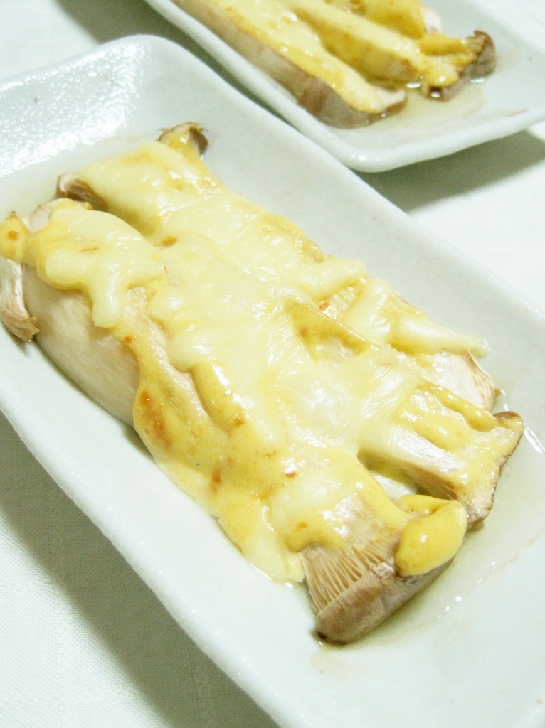 白い長方形のお皿に盛られたチーズの乗ったエリンギ。