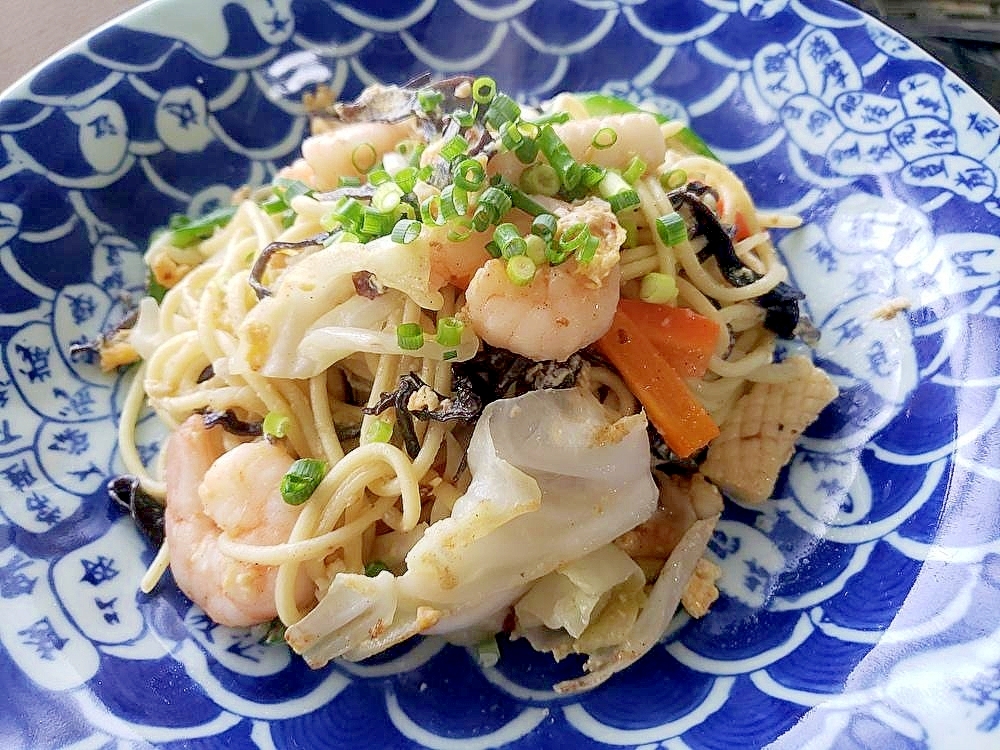 青い模様の皿に盛り付けたシーフードミックスの海鮮焼きそば