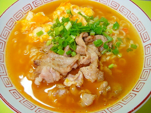 中華模様の丼鉢に盛りつけられた炒り卵と豚肉入りの辛ラーメン