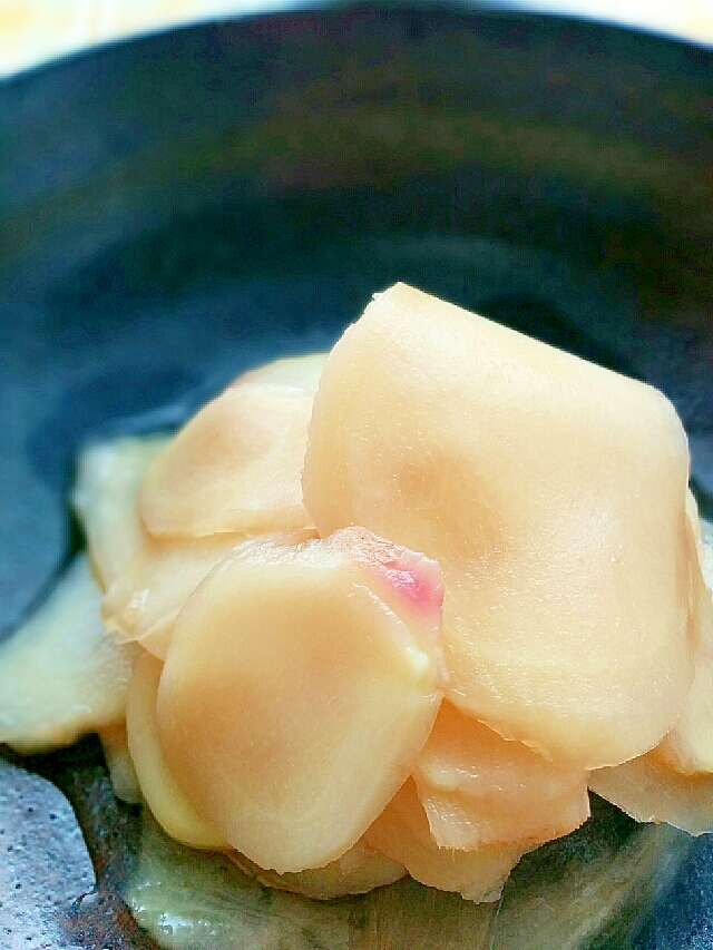 黒い丸皿に盛り付けられた新生姜の甘酢漬けのアップ