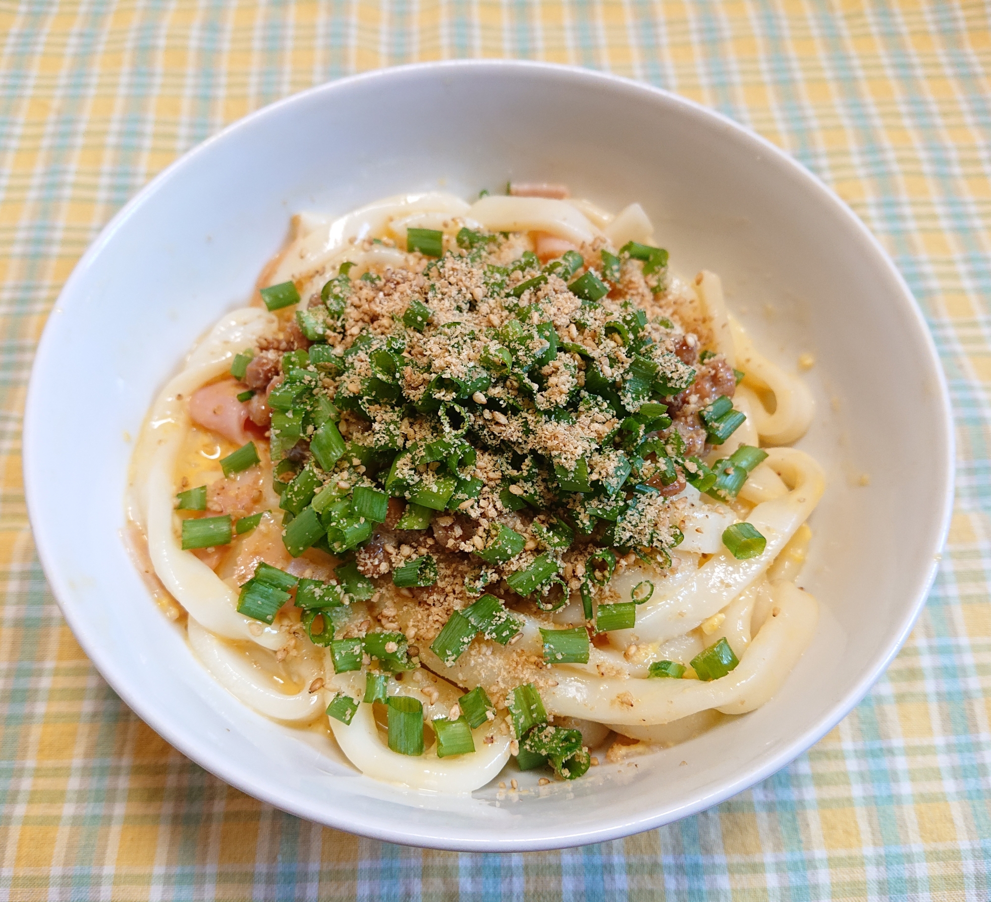 白い器に盛られているサラダチキンの納豆釜玉うどん