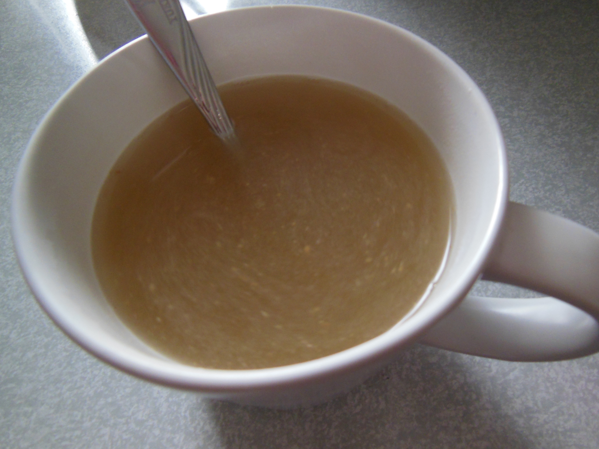 白いマグカップに入った生姜はちみつ湯