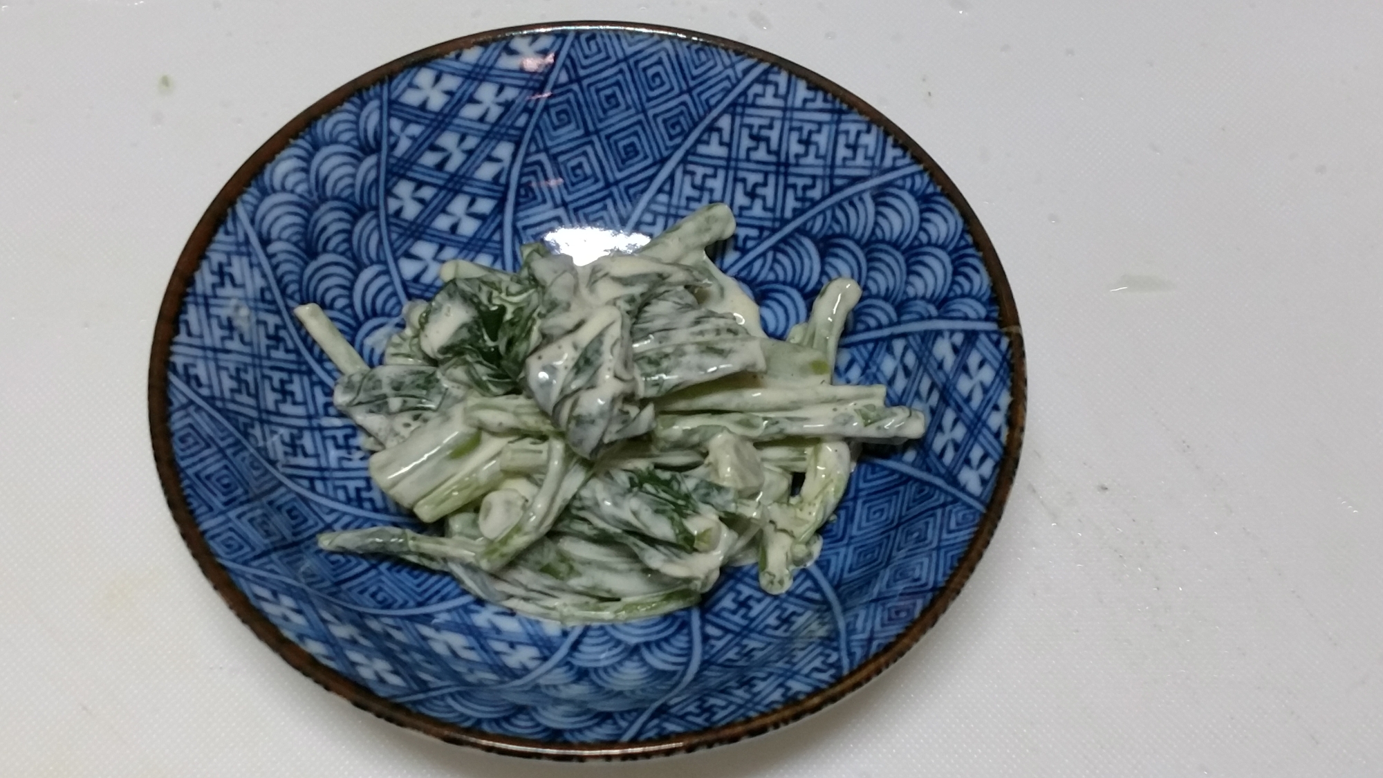 青い模様の小鉢に盛りつけられたかき菜のからしマヨネーズ和え