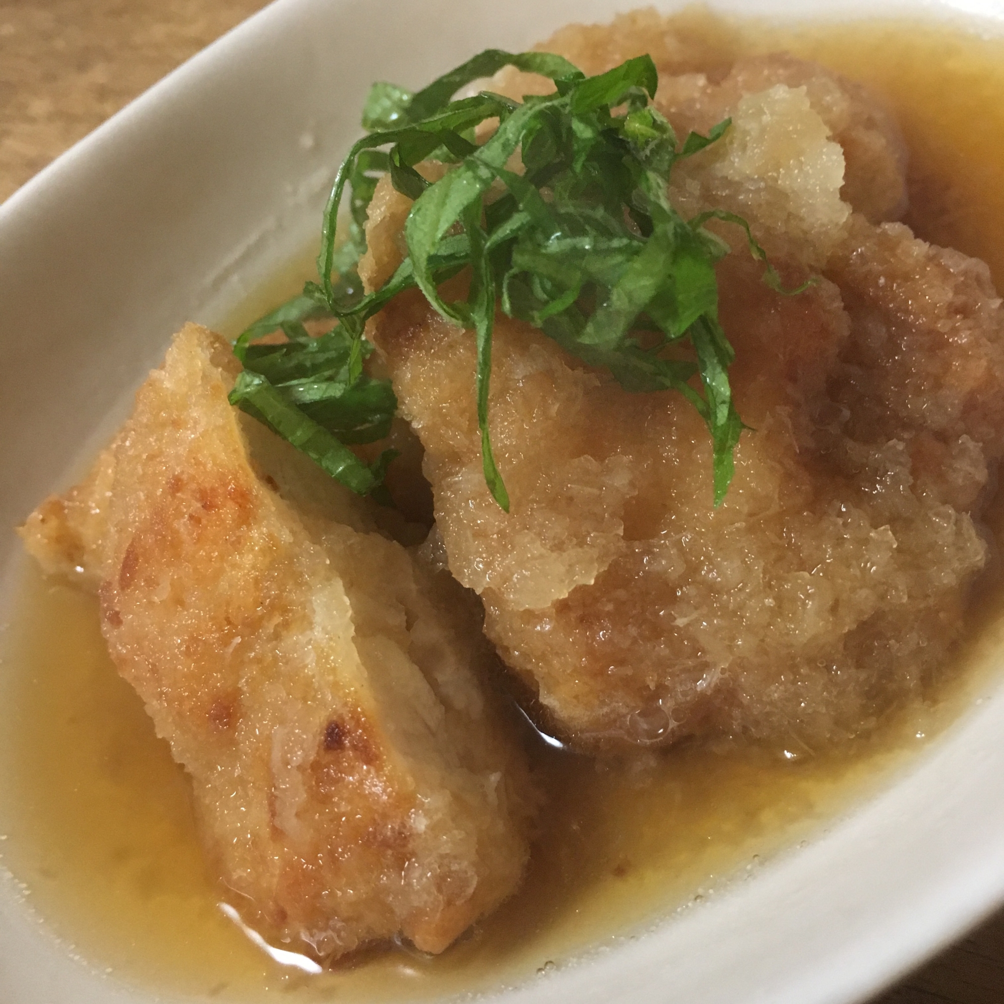 白い楕円形の皿に盛り付けたヒレカツのみぞれ煮
