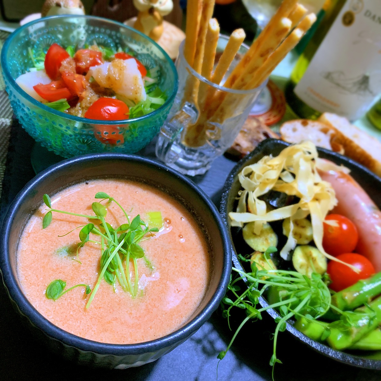 紺色のボウルに盛りつけられたホタテとアスパラの豆乳トマトスープ
