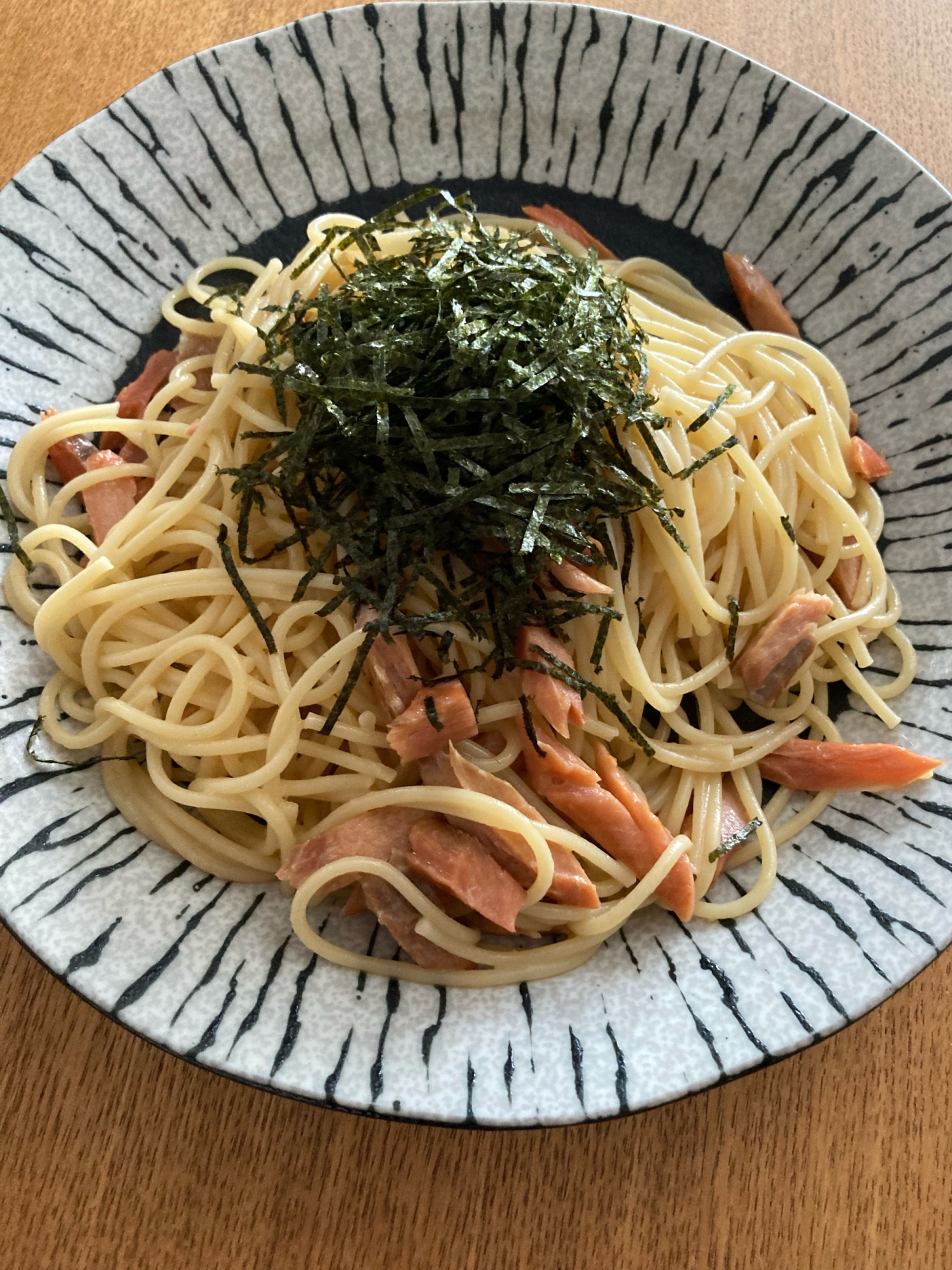 柄物の皿に盛りつけられた、鮭とばと刻み海苔のパスタ