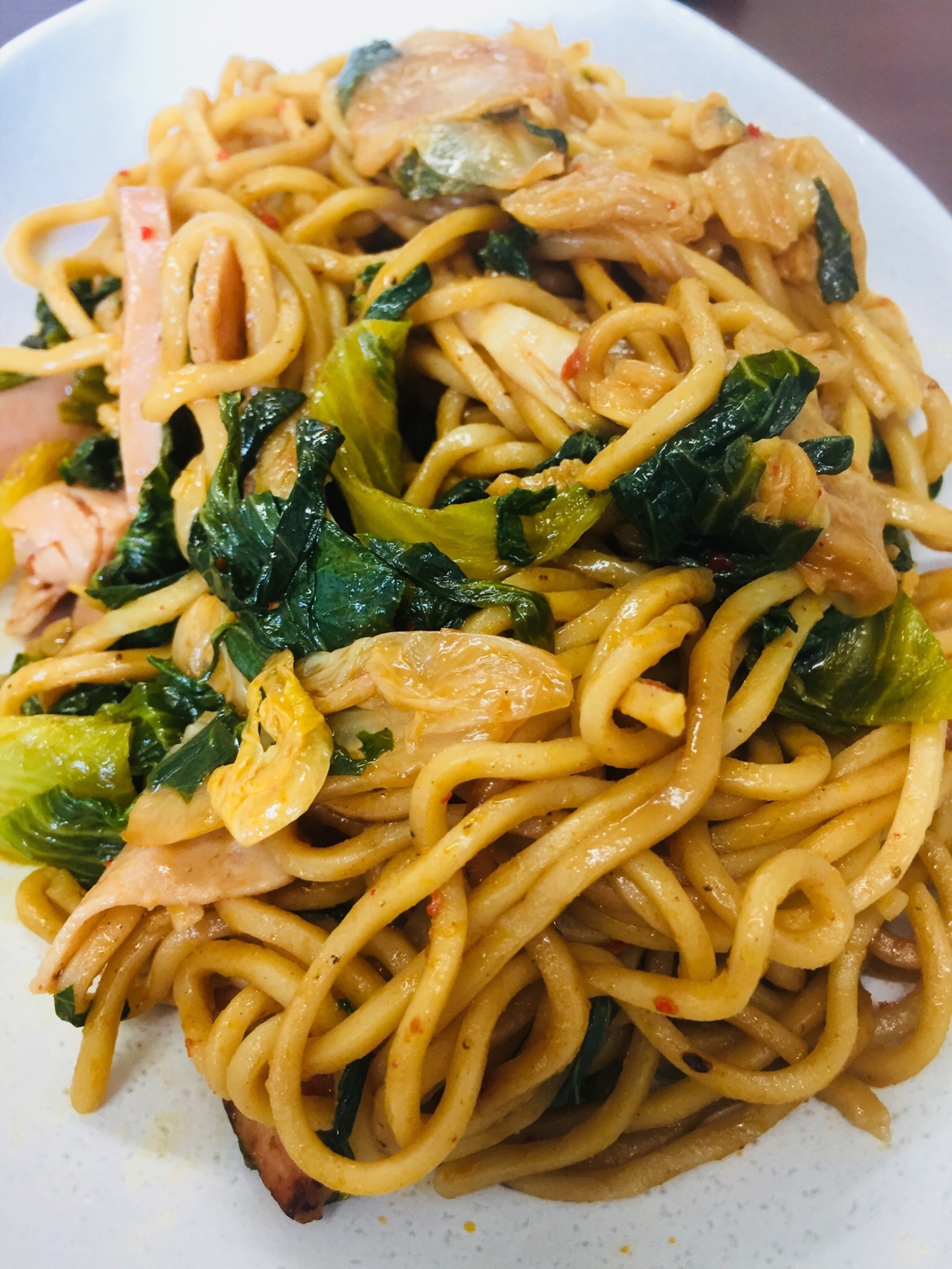 白い皿に盛り付けたレタスと白菜キムチの焼きそば