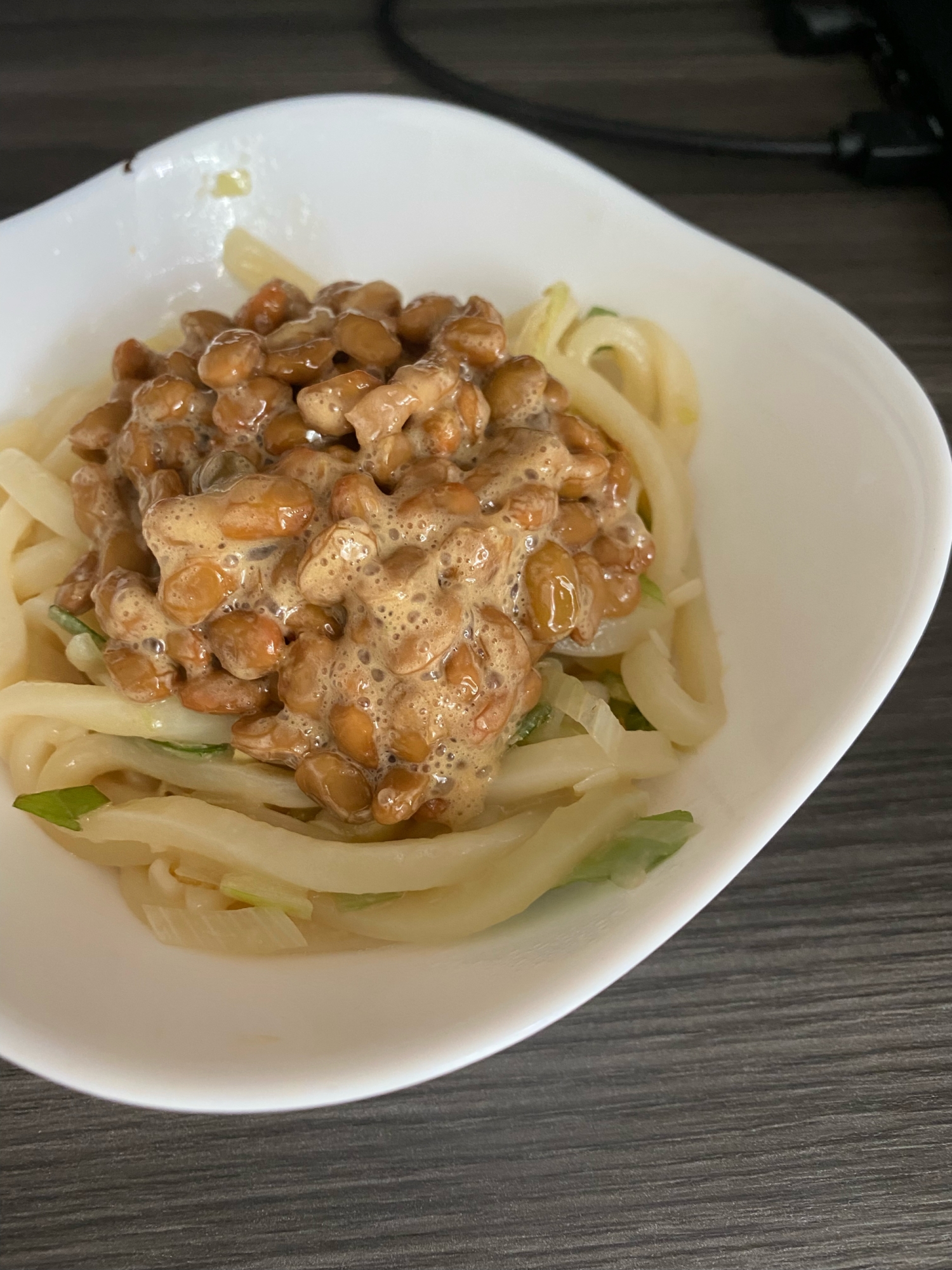 白い皿に盛られている納豆のごま油焼きうどん