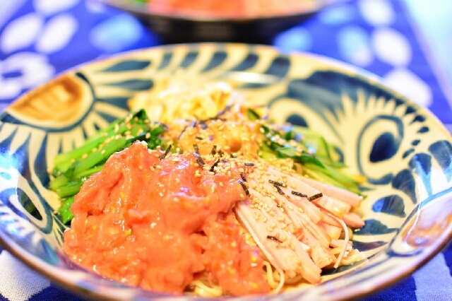 青い柄入りの皿に盛り付けられているトマトのスムージー冷麺