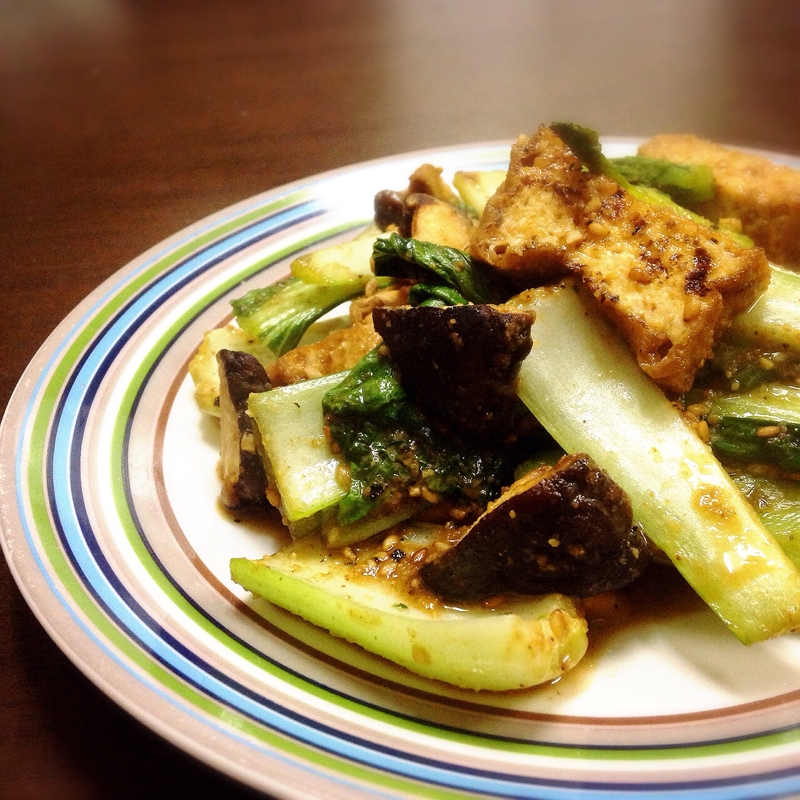 カラフルな模様入りの皿に盛り付けられている厚揚げと小松菜のごまみそ炒め