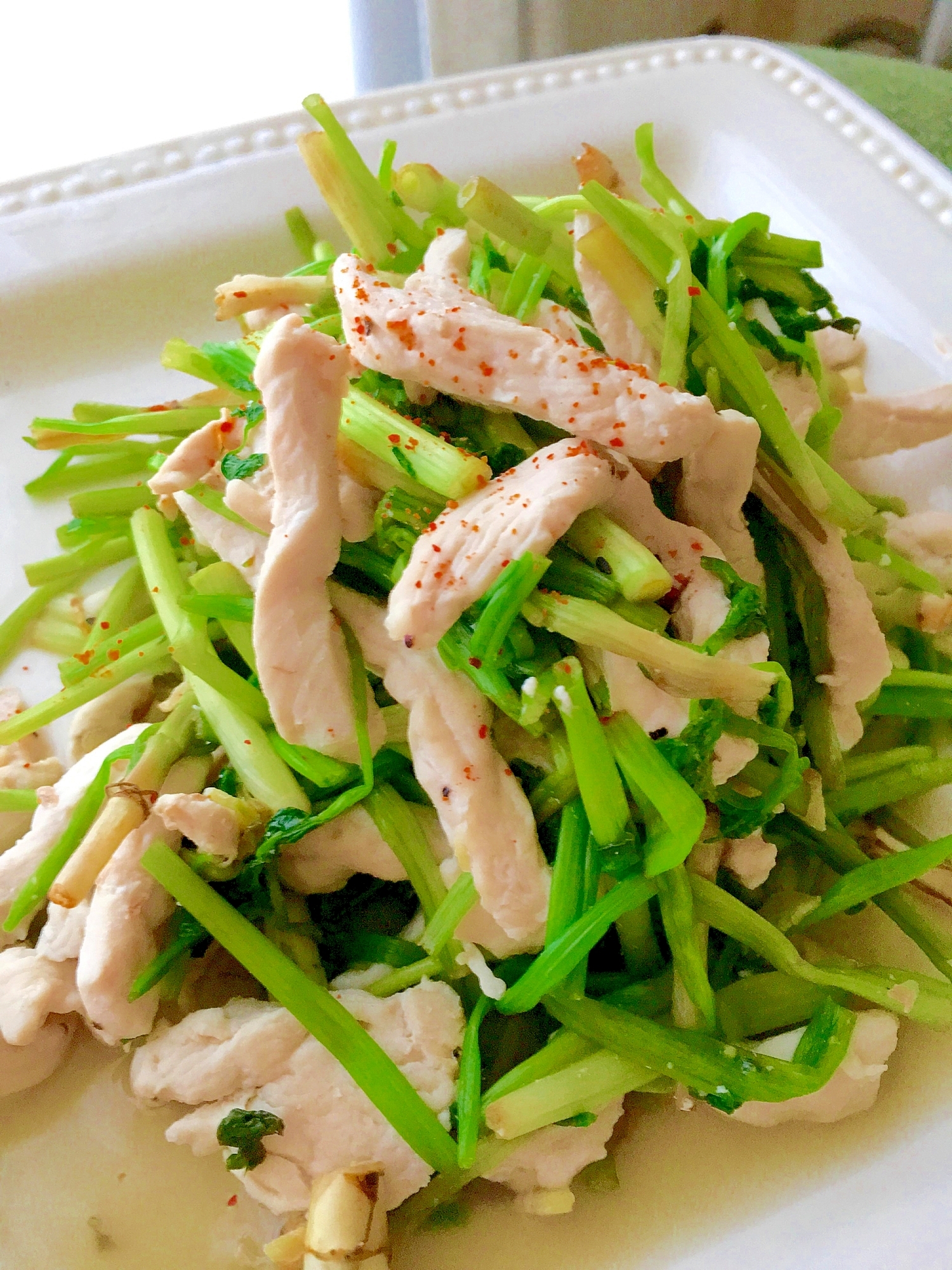 白い皿に入ったせりと鶏むね肉の塩炒め