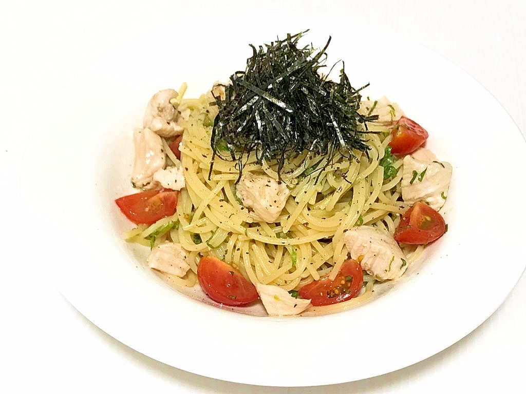 白い丸皿に盛られた鶏むね肉とミニトマトの和風冷製パスタ