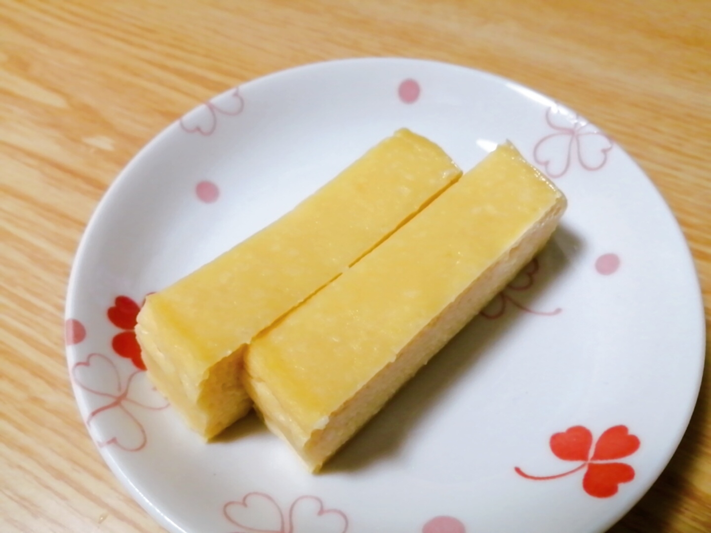 赤いリーフ柄の皿に盛られている豆腐の粉チーズケーキ