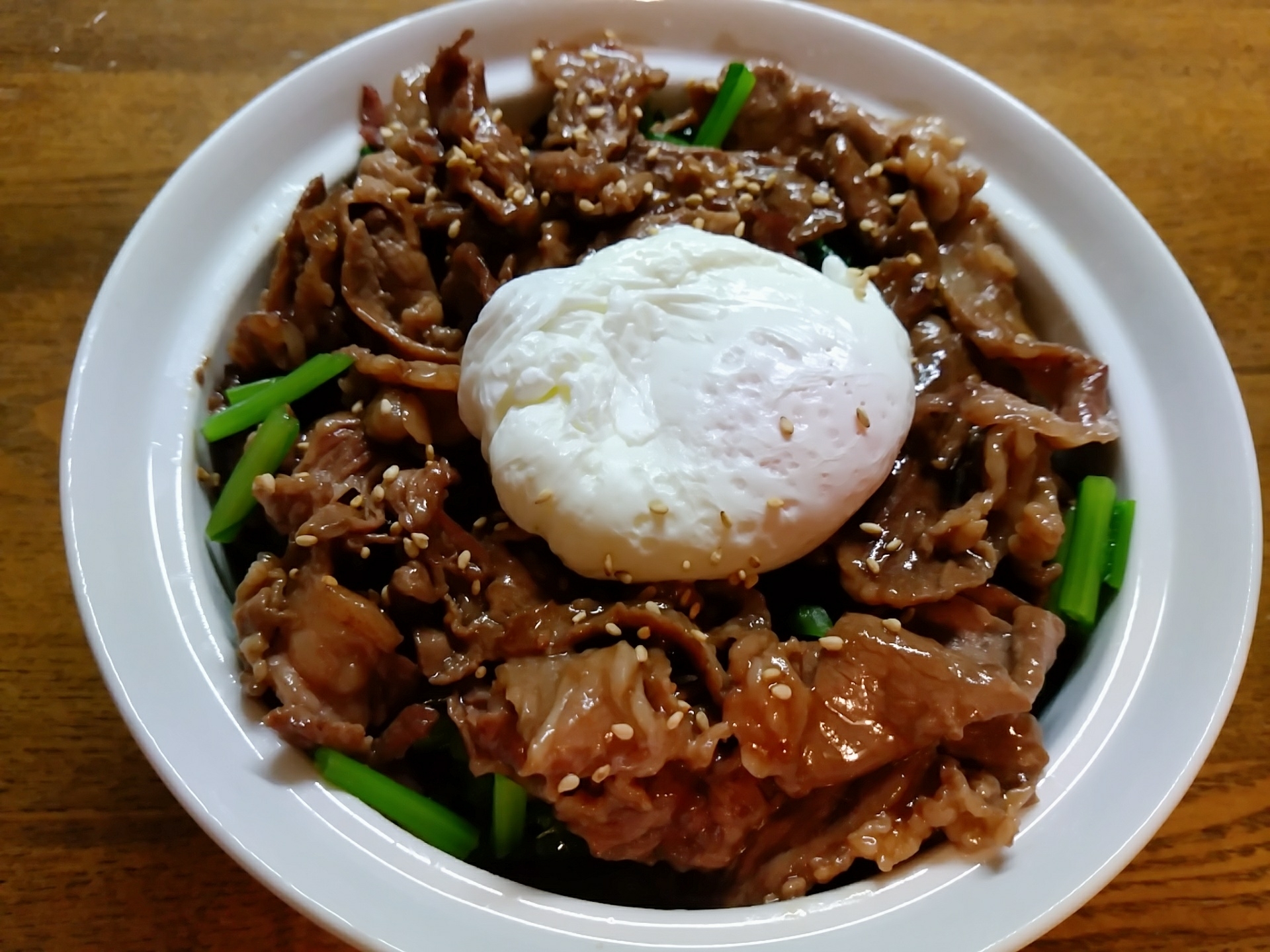 白い皿に盛り付けられた半熟卵のせ小松菜と牛肉の丼