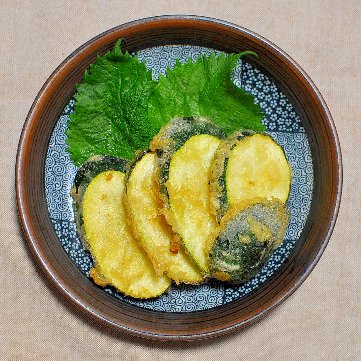 和柄の青い皿に盛られたズッキーニの天ぷら