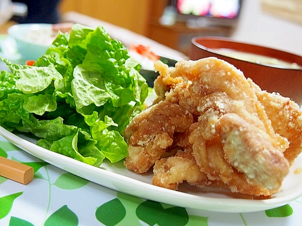 白い長皿に盛りつけられた、鶏もも肉の唐揚げと野菜のつけ合わせ