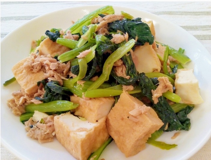 白い皿に盛り付けられている厚揚げと小松菜とツナ缶の炒め物