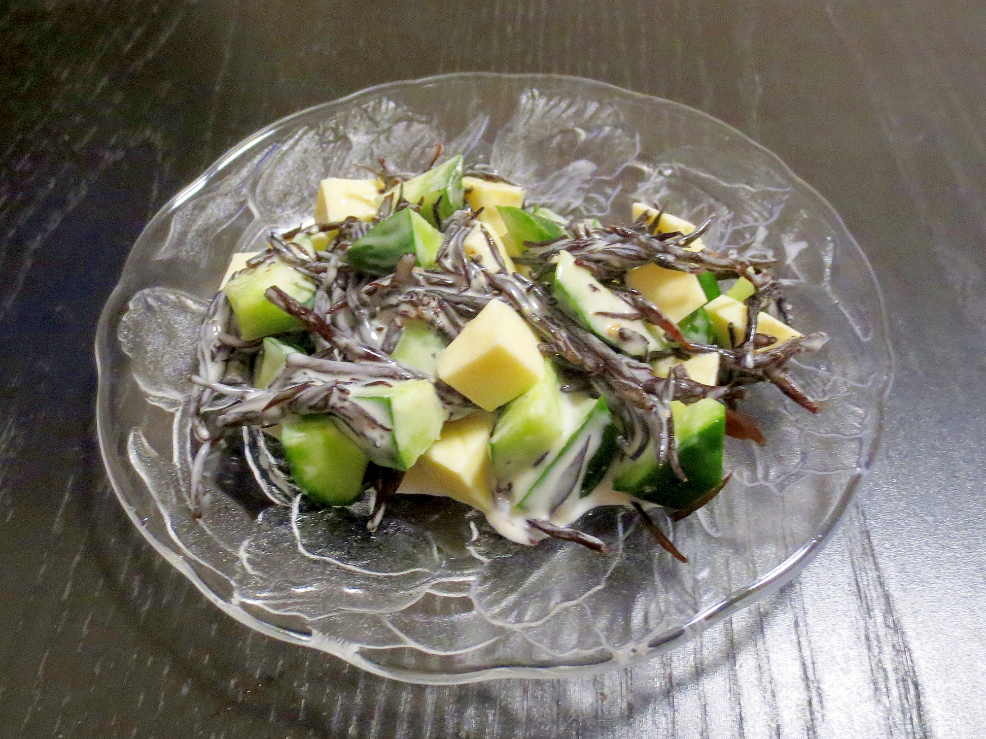 透明な皿にきゅうりとひじきのわさびマヨネーズサラダが盛られている様子