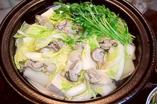 茶色の土鍋に入っている生かきと白菜、長ねぎなどの塩鍋