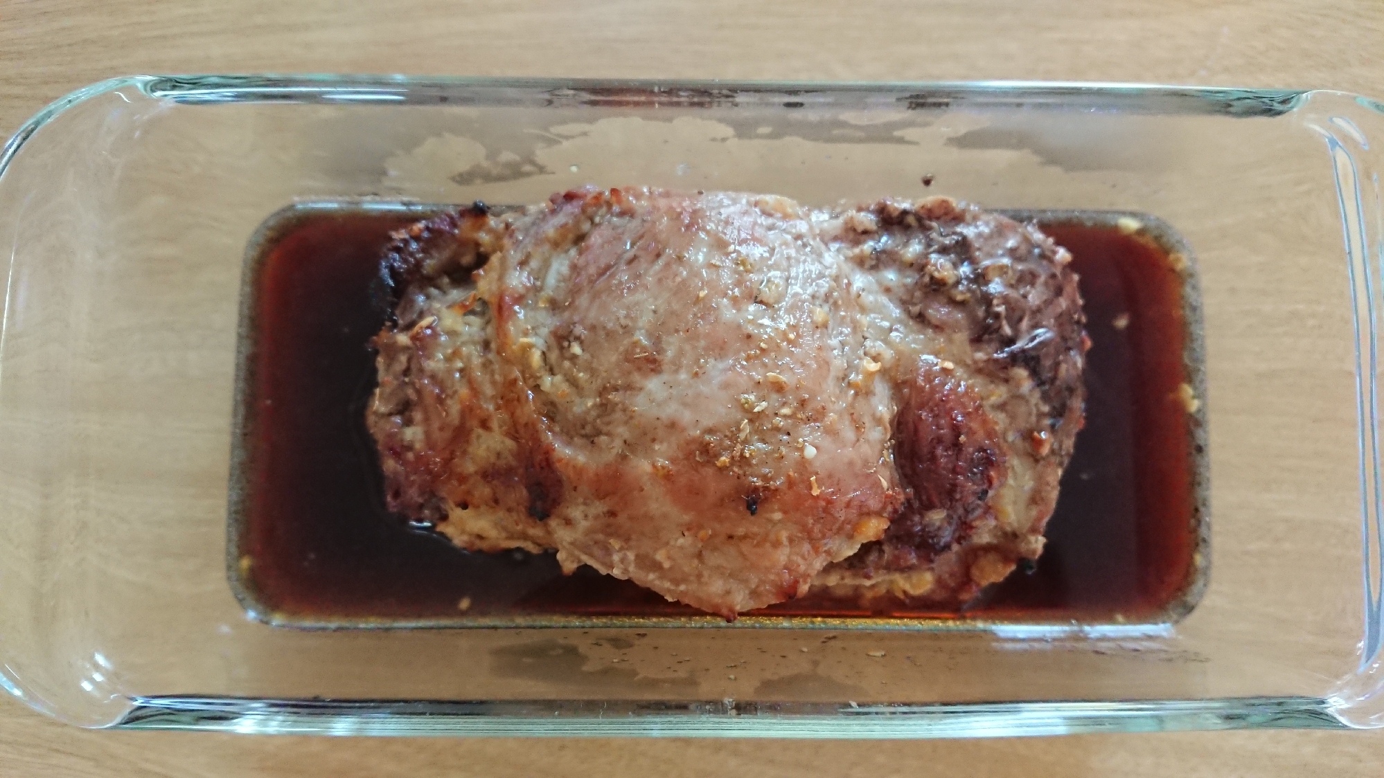 ガラスの耐熱皿に入った豚肩ロース肉のオーブン焼き